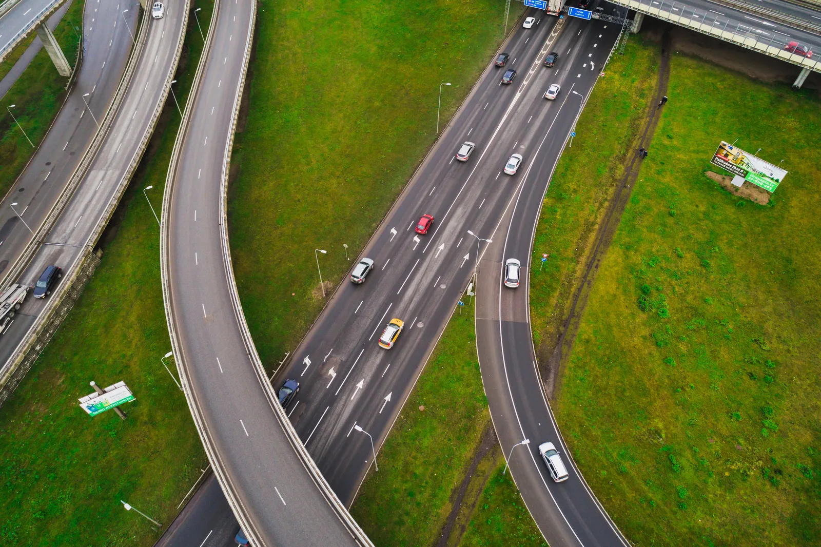 Aerial view of cars navigating a multi-lane highway interchange and overpass.