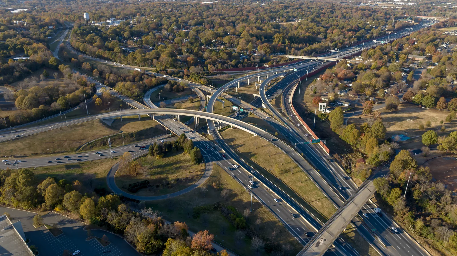 Aerial view of a complex highway interchange surrounded by autumn trees.